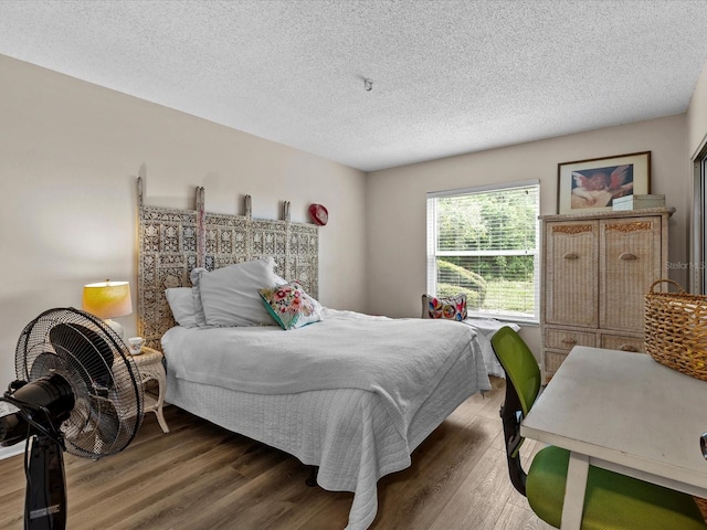 bedroom featuring a textured ceiling and dark hardwood / wood-style flooring