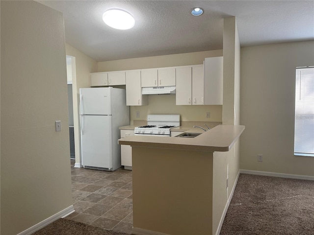 kitchen featuring dark colored carpet, white appliances, sink, kitchen peninsula, and white cabinetry