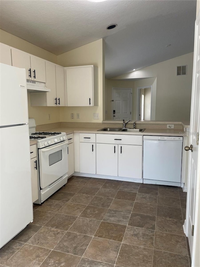 kitchen with lofted ceiling, white appliances, sink, and white cabinets