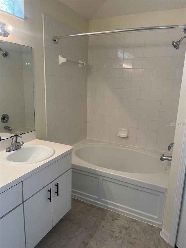 bathroom featuring tiled shower / bath combo and vanity