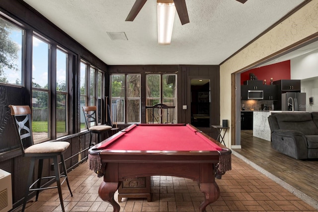 recreation room with a textured ceiling, ceiling fan, and pool table