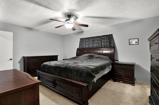 carpeted bedroom featuring ceiling fan and a textured ceiling