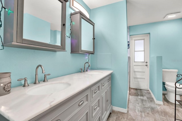 bathroom featuring toilet, vanity, and hardwood / wood-style flooring