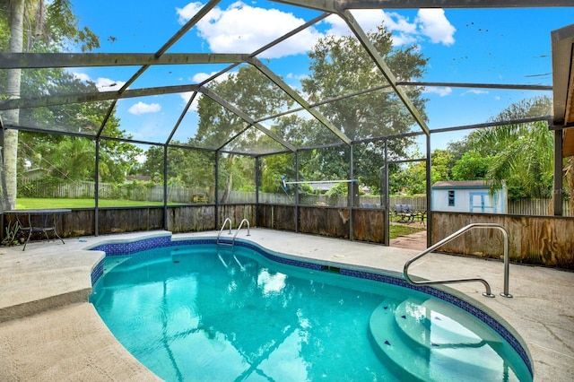 view of swimming pool featuring a storage unit, a patio area, and glass enclosure