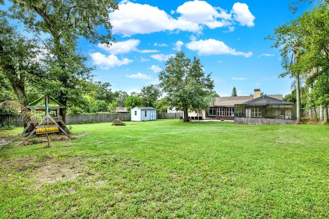 view of yard with a storage shed and a playground