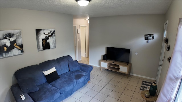 living room with a textured ceiling and light tile patterned flooring