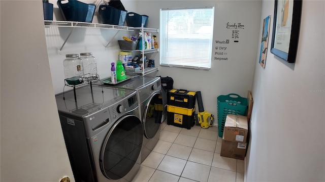 clothes washing area featuring washing machine and dryer and light tile patterned flooring