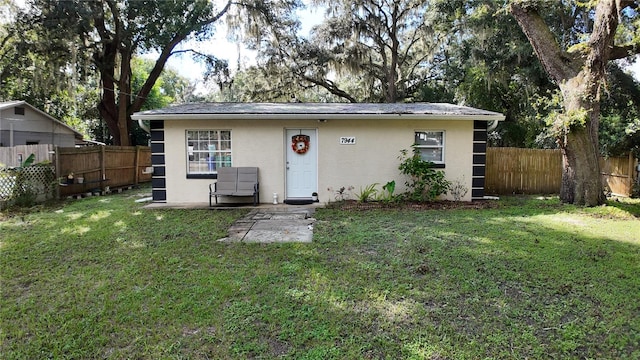 back of house with a yard and a patio