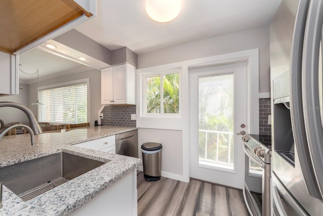 kitchen featuring light hardwood / wood-style floors, white cabinetry, a healthy amount of sunlight, and stainless steel appliances