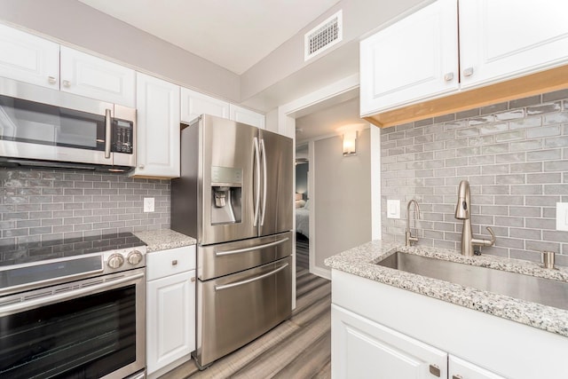 kitchen featuring light hardwood / wood-style flooring, appliances with stainless steel finishes, sink, and white cabinets