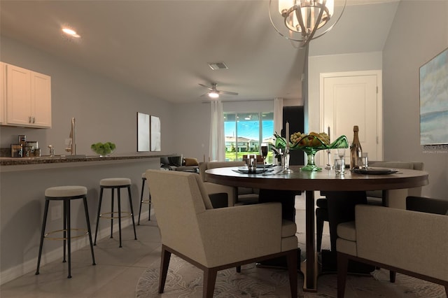 tiled dining space with ceiling fan with notable chandelier