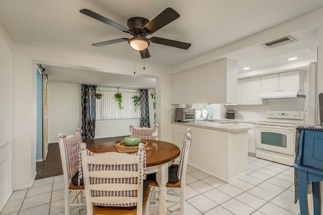 dining room with ceiling fan, light tile patterned flooring, sink, and a textured ceiling