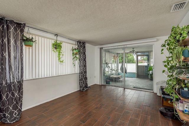 unfurnished room with a textured ceiling and dark hardwood / wood-style floors