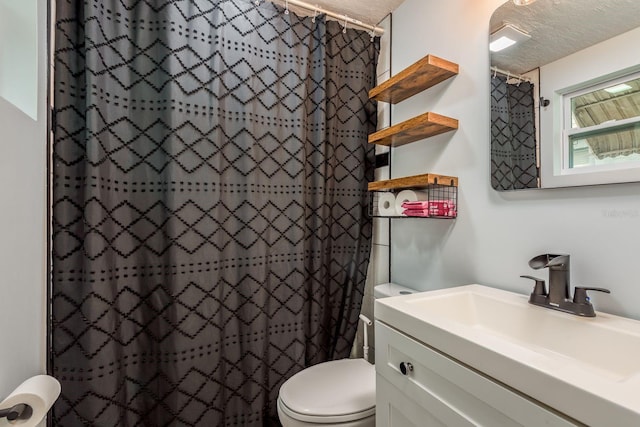 bathroom featuring a textured ceiling, walk in shower, vanity, and toilet