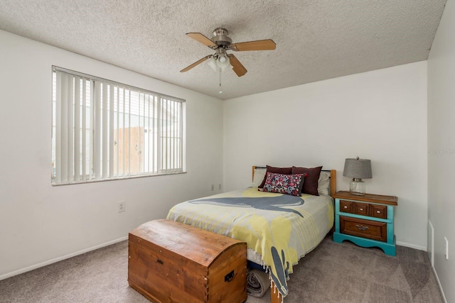 carpeted bedroom with ceiling fan and a textured ceiling