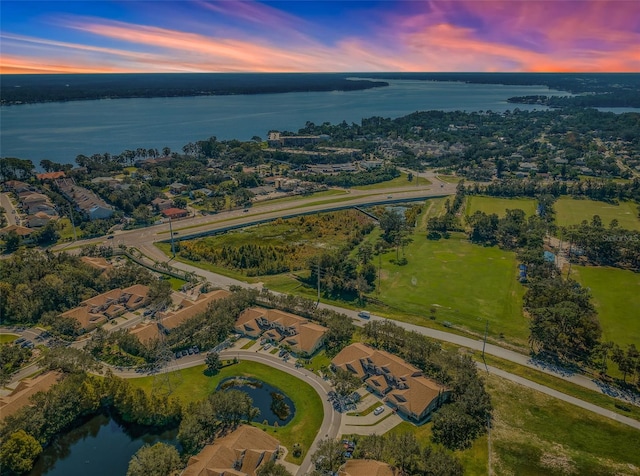 aerial view at dusk featuring a water view