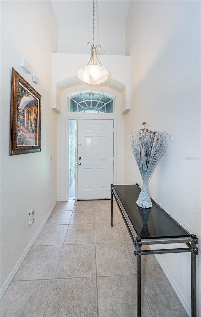 entrance foyer with high vaulted ceiling and light tile patterned floors