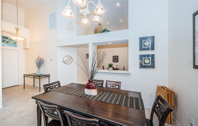 dining room with a towering ceiling and light tile patterned floors