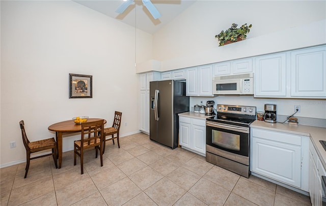 kitchen featuring high vaulted ceiling, white cabinetry, appliances with stainless steel finishes, and light tile patterned floors