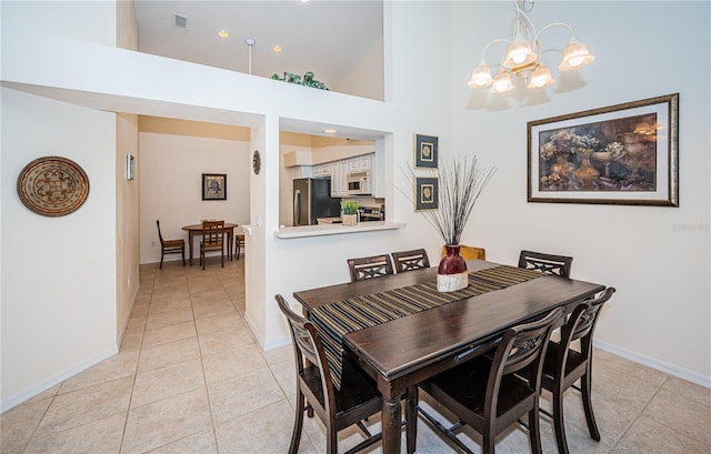 tiled dining room featuring an inviting chandelier and high vaulted ceiling