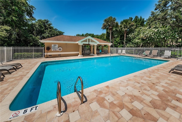 view of pool featuring an outbuilding and a patio