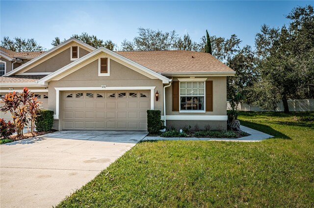 656 Spring Lake Cir W, Tarpon Springs, FL 34688 - view of front of house with stucco siding, an attached garage, and a front yard