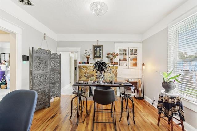 dining area featuring light wood-type flooring and plenty of natural light