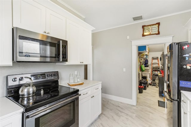 kitchen featuring ornamental molding, stainless steel appliances, and white cabinets