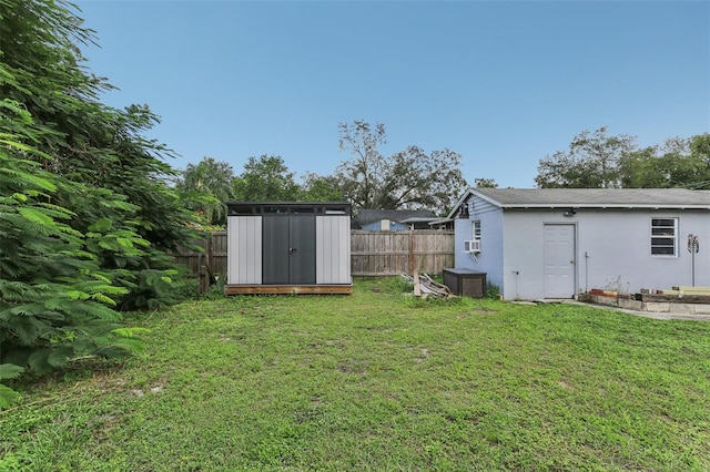 view of yard featuring cooling unit and a shed