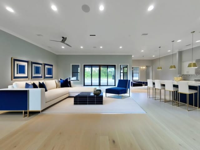 living room with ceiling fan, light hardwood / wood-style flooring, and crown molding