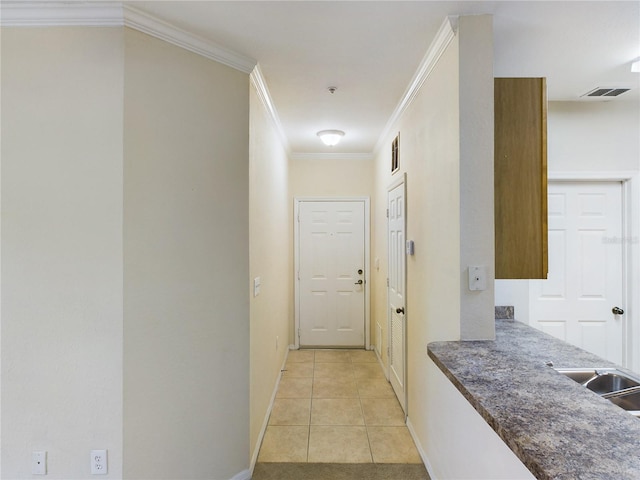 corridor with sink, light tile patterned floors, and ornamental molding