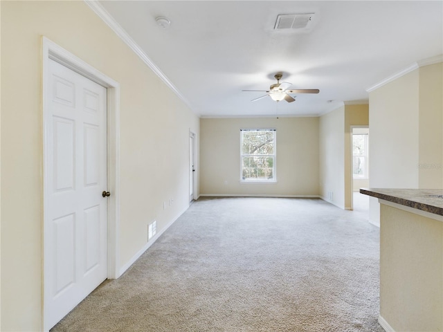 unfurnished living room featuring light carpet, ceiling fan, and crown molding