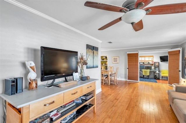 living room with ceiling fan, ornamental molding, and light hardwood / wood-style flooring