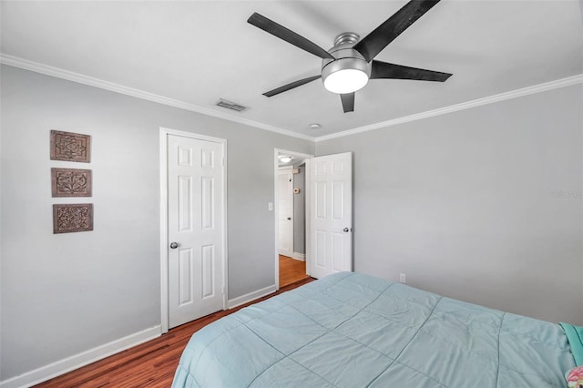 bedroom with ornamental molding, hardwood / wood-style floors, and ceiling fan