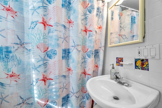 bathroom with sink and tile walls