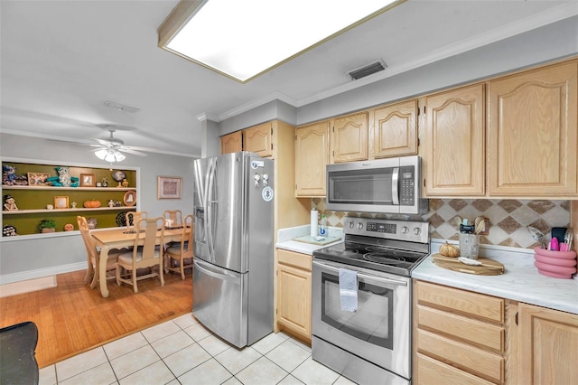 kitchen featuring crown molding, appliances with stainless steel finishes, and light brown cabinets