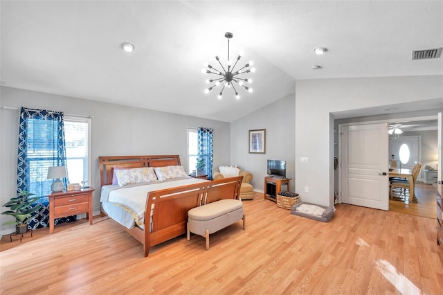 bedroom with vaulted ceiling, a notable chandelier, multiple windows, and light wood-type flooring