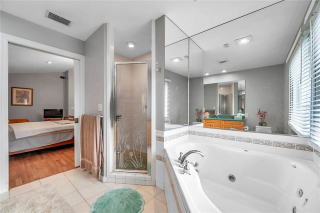 bathroom with vanity, vaulted ceiling, shower with separate bathtub, and tile patterned flooring