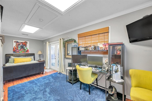 bedroom with crown molding, hardwood / wood-style flooring, and french doors