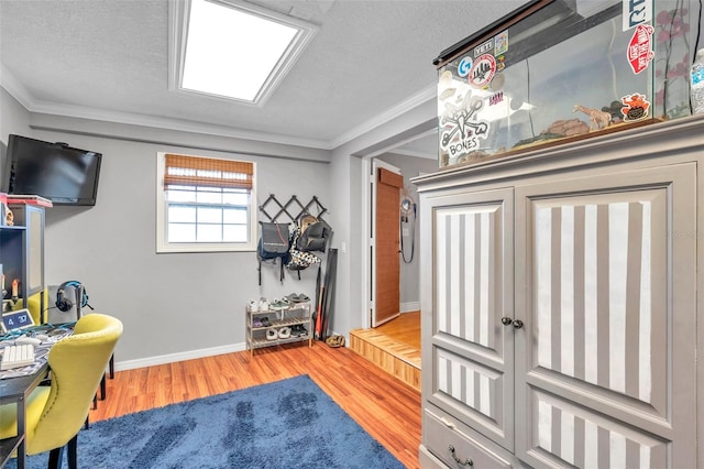 interior space featuring a textured ceiling, wood-type flooring, and ornamental molding