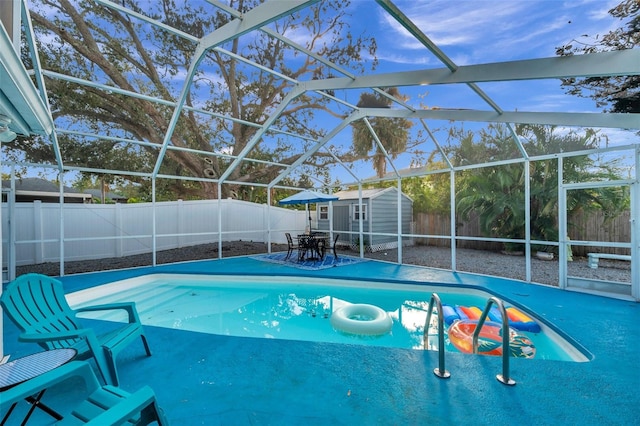 view of pool with a patio area, a storage unit, and a lanai