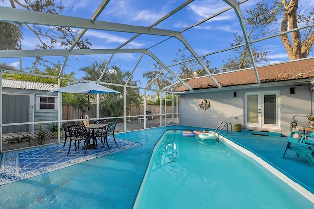 view of swimming pool featuring a patio, french doors, an outdoor structure, and a lanai