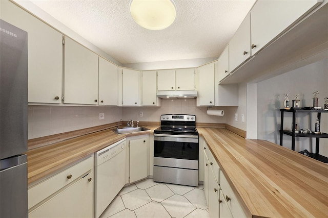 kitchen with decorative backsplash, appliances with stainless steel finishes, sink, and wood counters