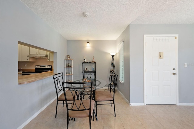 tiled dining room with a textured ceiling