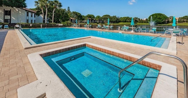 view of swimming pool with a hot tub and a patio area