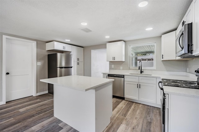 kitchen with a kitchen island, sink, stainless steel appliances, and white cabinets