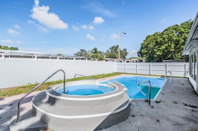 view of swimming pool with a patio and a hot tub