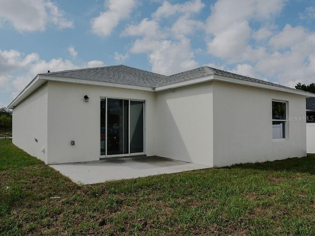 back of property with a patio area and a yard