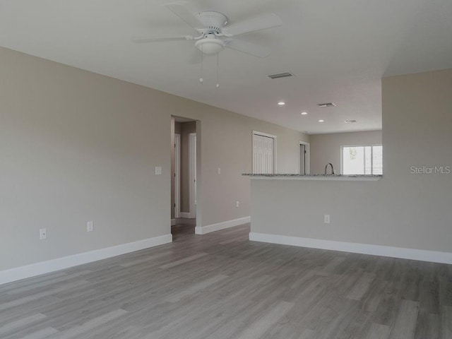 spare room with light hardwood / wood-style floors, ceiling fan, and sink