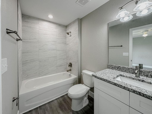 full bathroom featuring vanity, hardwood / wood-style flooring, toilet, and tiled shower / bath